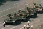 Мужчина стоит один, чтобы заблокировать линию танков, направляющихся на восток на бул. Канган в Пекине
