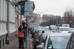 Работники коммунальных служб снимают мешки, закрывавшие знаки о платных парковках