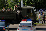 Военный грузовик с вооруженными пророссийскими боевиками проезжает полицейский контрольно-пропускной пункт в аэропорту Донецка 