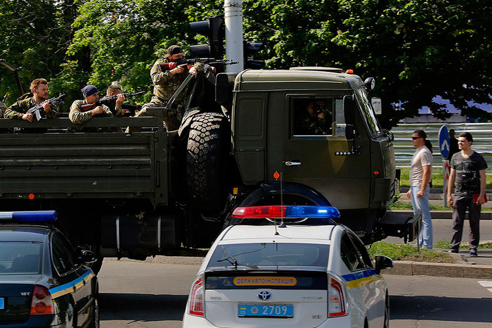 Военный грузовик с&nbsp;вооруженными пророссийскими боевиками проезжает полицейский контрольно-пропускной пункт в&nbsp;аэропорту Донецка 