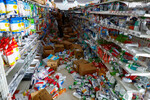 Люди забирают товары с полок поврежденной аптеки после получения разрешения на их бесплатный вывоз после землетрясения в Анамидзу, 2 января 2024 года

