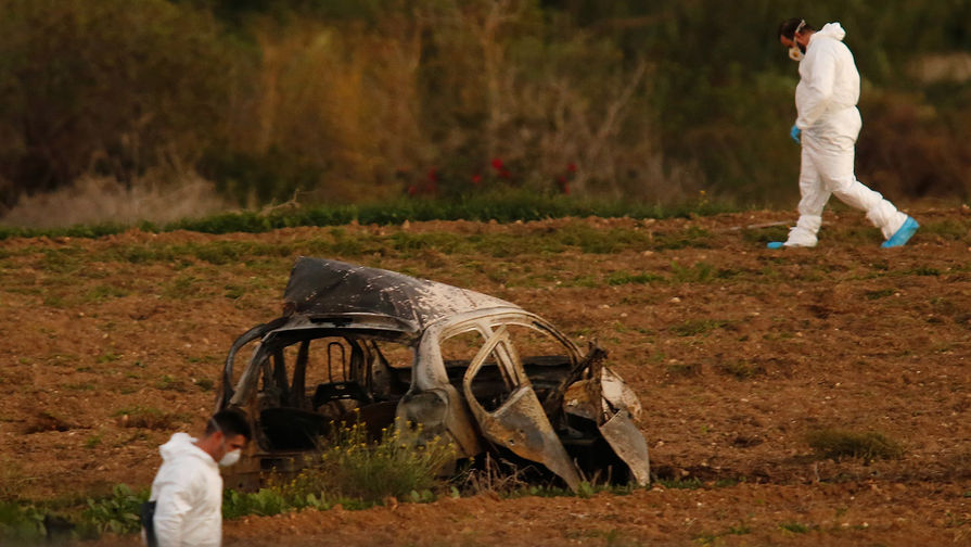 Криминалисты около взорванного автомобиля журналистки Дафне Каруаны Галиции на Мальте, 16 октября 2017 года
