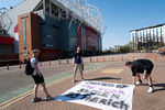 Болельщики размещают баннер у стадиона в Манчестере, 19 апреля 2021 года