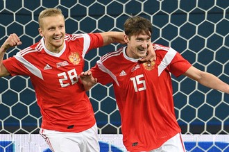 Игроки сборной России Игорь Смольников и Алексей Миранчук (справа) радуются забитому мячу в товарищеском матче между сборными командами России и Испании.
