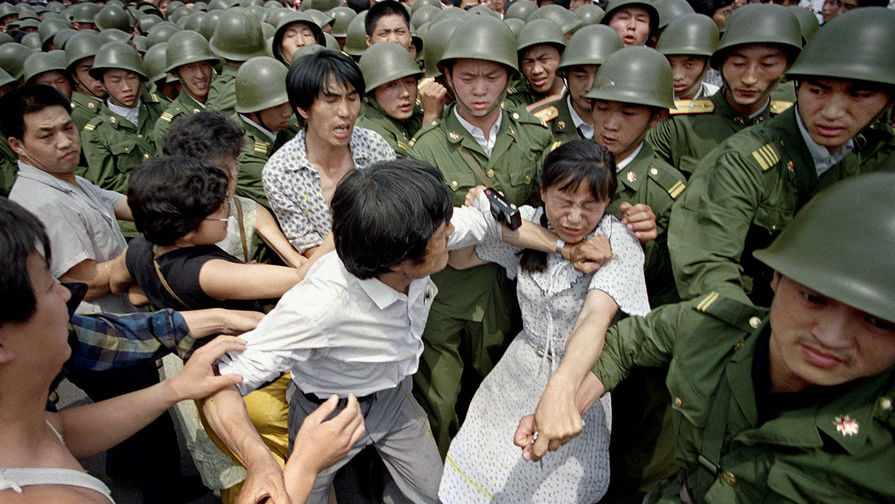 Молодая женщина между&nbsp;гражданскими лицами и китайскими солдатами, 3 июня 1989 года