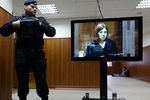 Полицейский наблюдает за выступлением Надежды Толоконниковой в зале суда, 12 октября 2012 года 
