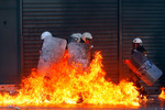 6 сентября. Группа греческих полицейских объятых пламенем от коктейля Молотова, брошенного демонстрантами во время акции протеста в Афинах. 