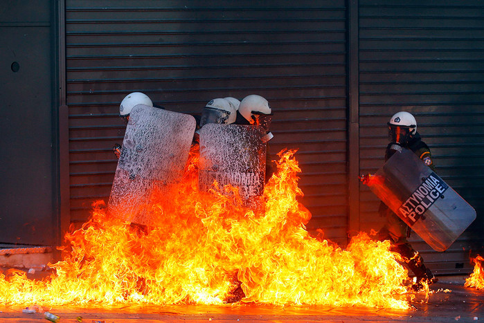 6&nbsp;сентября. Группа греческих полицейских объятых пламенем от коктейля Молотова, брошенного демонстрантами во время акции протеста в&nbsp;Афинах. 