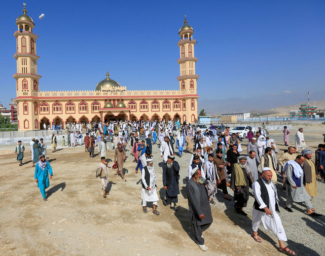 Мужчины покидают мечеть после молитвы в день праздника Ураза-байрам в провинции Лагман, Афганистан, 24 мая 2020 года