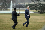 Охранник предлагает зонт президенту США Джо Байдену во время дождя на южной лужайке Белого дома в Вашингтоне, 16 февраля 2023 года