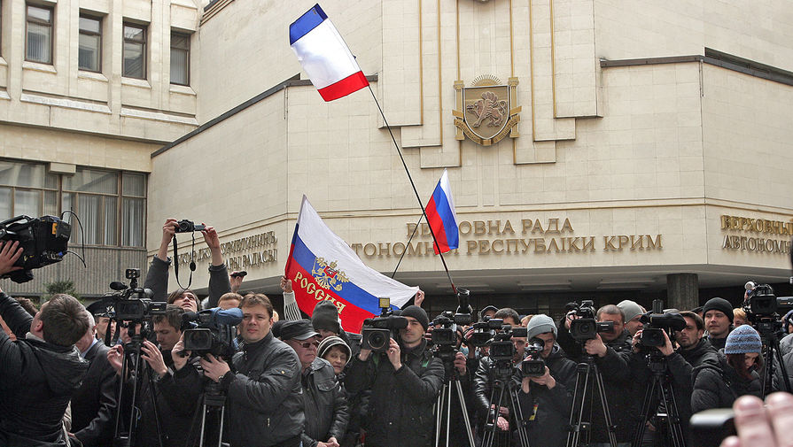 Журналисты работают у здания Верховного совета Крыма в Симферополе, где проходит митинг, 25 февраля 2014 года