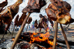 Представитель племени масаи готовит мясо на Первой неделе культуры Маа в Национальном заповеднике Масаи-Мара, Кения, 22 августа 2023 года