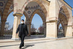 Мужчина в защитной маске в мечети «Сердце Чечни» имени А.Х. Кадырова в Грозном