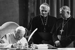 Папа Иоанн Павел II подписывает новый Кодекс канонического права в Ватикане в 1983 году. Рядом с ним — кардинал Йозеф Ратцингер и архиепископ Розалио Хосе Кастильо Лара
