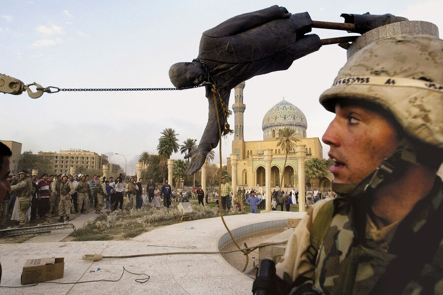 Американские военнослужащие у статуи Саддама Хусейна в Ираке, 9 апреля 2003 года