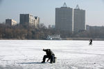 Мужчина рыбачит на замерзшей реке в Донецке