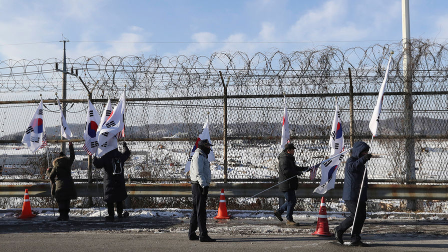 Жители Южной Кореи стоят с флагами у границы с Северной Кореей, 25 января 2018 года