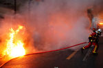 Тушение горящего автомобиля во время беспорядков, возникших во время акции протеста в Париже, 5 декабря 2020 года