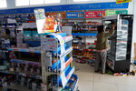 Женщина забирает товары с полок поврежденной аптеки после получения разрешения от владельца магазина взять их бесплатно после землетрясения в Анамидзу, 2 января 2024 года 