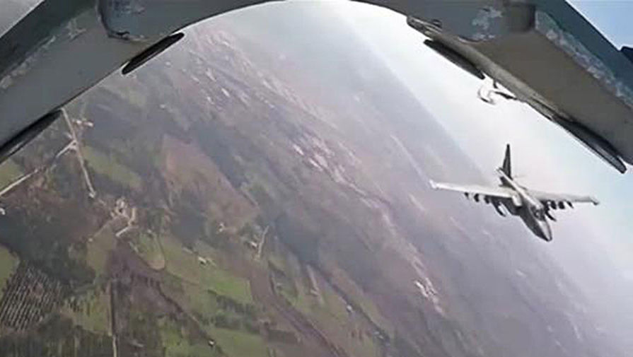 Российский штурмовик Су-25 во время вылета с авиабазы Хмеймим на боевое задание в сопровождении сирийских истребителей МиГ-29. Снимок с видео