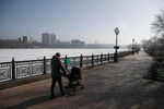 Мужчина гуляет с ребенком у замерзшей реки в Донецке