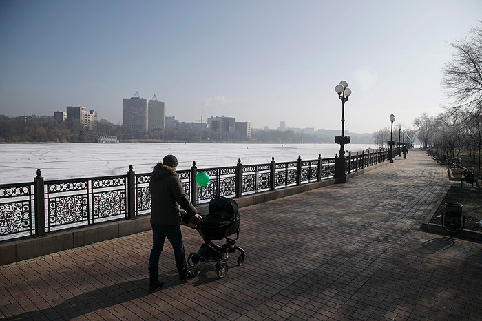Мужчина гуляет с&nbsp;ребенком у&nbsp;замерзшей реки в&nbsp;Донецке