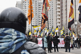 Сотрудник ОМОНа и участники акции «Русский марш» в Москве