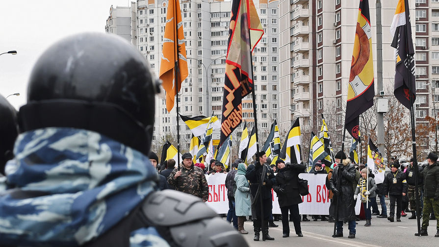 Сотрудник ОМОНа и участники акции «Русский марш» в Москве
