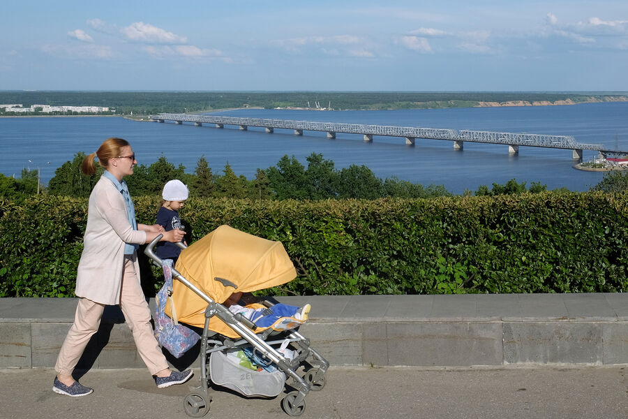 Женщина гуляет с детьми на одной из улиц Ульяновска, откуда открывается вид на Императорский мост 