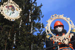 Рабочий украшает ёлку, установленную возле Северного речного вокзала в Москве, декабрь 2020 года