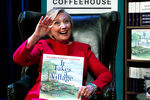 Бывший госсекретарь США Хиллари Клинтон с экземпляром своей книги «Нужна целая деревня» во время обсуждения мемуаров «Что произошло» в театре Уорнера в Вашингтоне, сентябрь 2017 года