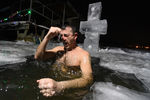 Мужчина окунается в иордань во время празднования Крещения в Третьем заливе Красноярского водохранилища на реке Енисей, 19 января 2022 года