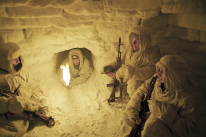 Военнослужащие Отдельного арктического пограничного отряда сидят в снежном чуме во время пурги