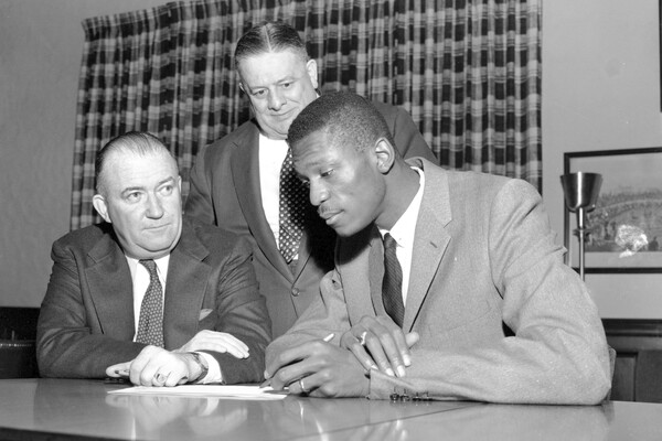 Билл Рассел (справа) подписывает контракт с&nbsp;клубом НБА «Бостон Селтикс» в&nbsp;Бостон-Гарден в&nbsp;Бостоне, штат Массачусетс, 1956&nbsp;год