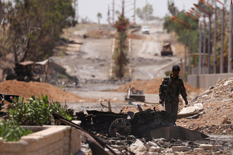 Ополченец «Демократических сил Сирии» (SDF) на улице отбитого у террористов сирийского города Табка, 12 мая 2017 года