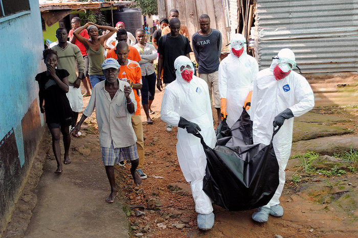 Бригада врачей выносит тело 29-летнего местного жителя, погибшего от вируса Эбола в&nbsp;Монровии