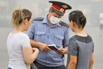 Сотрудник милиции в медицинской маске во время проверки документов на одной из улиц столицы, август 2010 года 