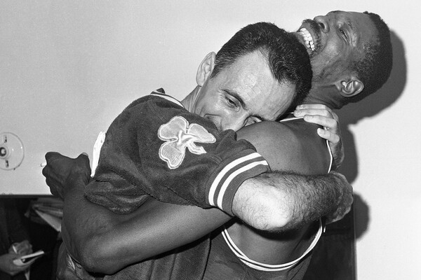 Билл Рассел обнимает товарища по&nbsp;команде Боба Кузи в&nbsp;раздевалке Бостона после того, как «Селтикс» выиграли свой пятый подряд чемпионат НБА, обыграв «Лейкерс» в&nbsp;Лос-Анджелесе, 1963&nbsp;год