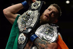 Конор Макгрегор с ирландским флагом и поясами UFC 