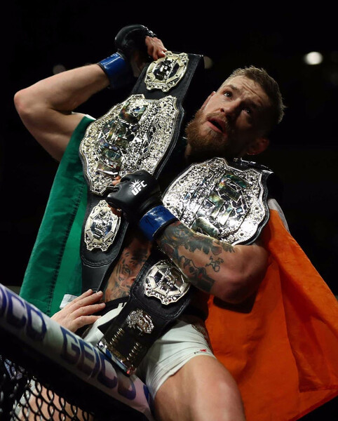 Конор Макгрегор с&nbsp;ирландским флагом и поясами UFC 