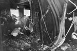 Пожарные и следователи осматривают последствия столкновения бомбардировщика B-25 со зданием Эмпайр-стейт-билдинг в Нью-Йорке, 28 июля 1945 года