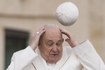 Папа Франциск пытается поймать головной убор (пилеолус), который сдуло ветром, во время своей еженедельной общей аудиенции на площади Святого Петра в Ватикане, 13 марта 2024 года