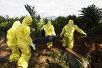 Похоронная команда несет тело умершего от вируса Эбола для захоронения