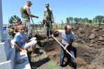 Жители Крымска и военнослужащие выкапывают могилы для погибших от наводнения, июль 2012 года