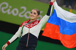 Алия Мустафина, завоевавшая золотую медаль в упражнениях на брусьях на соревнованиях по спортивной гимнастике среди женщин на XXXI летних Олимпийских играх, на церемонии награждения