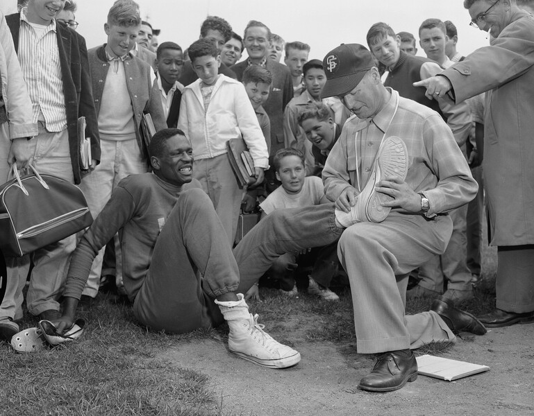 Тренер Билл Мангер из&nbsp;USF осматривает поврежденную во время соревнований ногу Билла Рассела, Сан-Франциско, 1956&nbsp;год