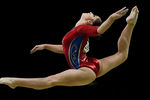 Алия Мустафина выполняет упражнения на бревне в командном многоборье среди женщин на соревнованиях по спортивной гимнастике на XXXI летних Олимпийских играх