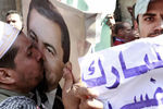 Мужчина целует портрет Хосни Мубарака во время демонстрации сторонников президента перед телецентром Каира, 2011 год