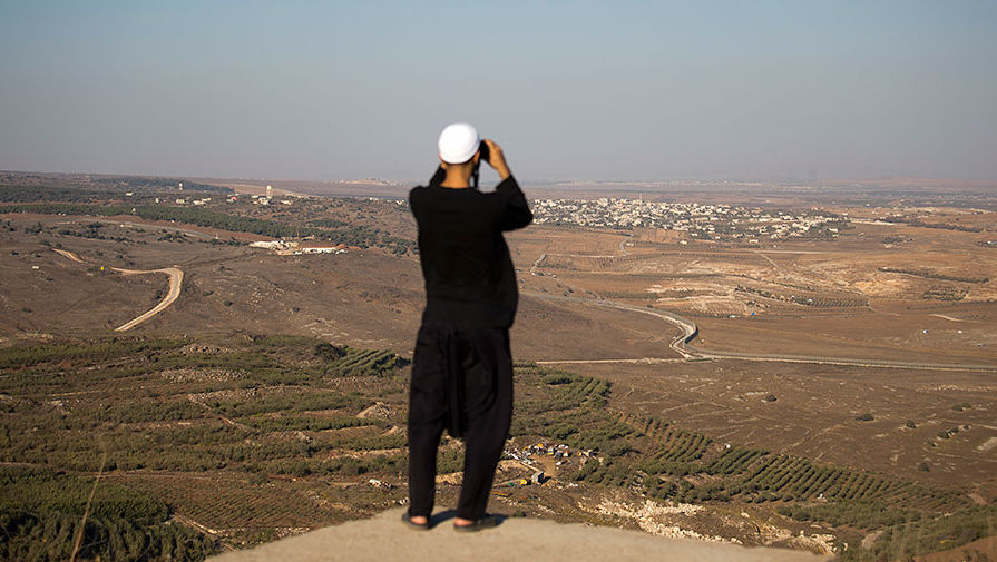 Друз смотрит со стороны Голанских высот на бои между лояльными Башару Асаду войсками и повстанцами