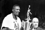Билл Расселл получает награду «Игрок года» от комиссара Национальной баскетбольной ассоциации (НБА) Уолтера Кеннеди во время перерыва в матче в Бостон-Гарден, 1964 год